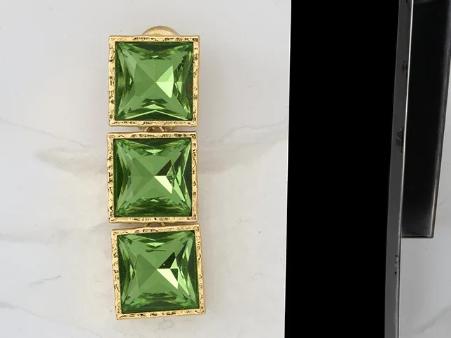Green gemstone drop earrings before colour correction under mixed light
