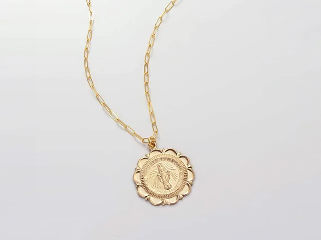 Gold coin pendant on a fine chain before a hand-drawn clipping path through the links
