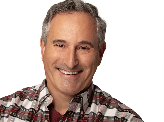 Smiling man in a checked shirt after headshot retouching and background removal