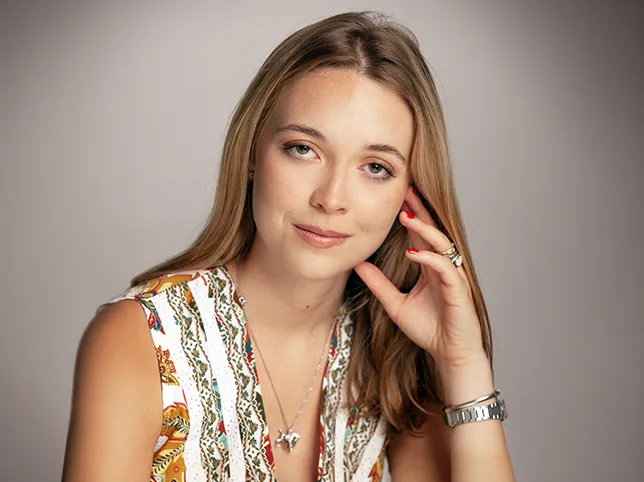 Model in an embellished top with skin evened and the background cleaned, texture kept