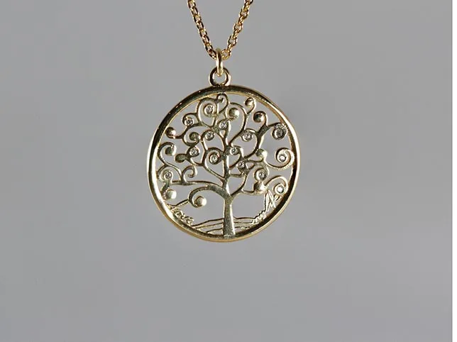 Gold tree-of-life pendant before product editing with a reflection added