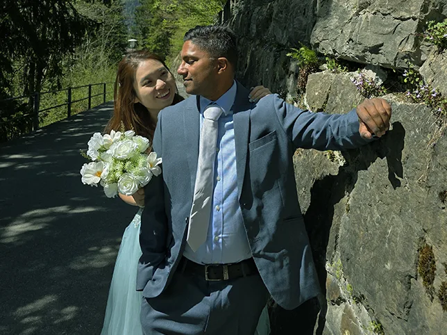 Bride and groom by a stone wall before wedding colour grading