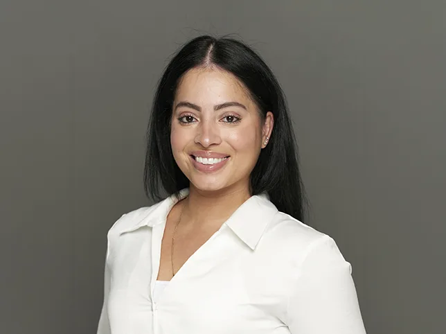 Woman in a white shirt before headshot retouching and a replaced backdrop