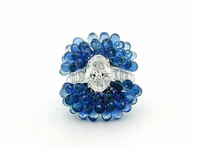 Sapphire and diamond cluster ring before shadow work that sits it on the page