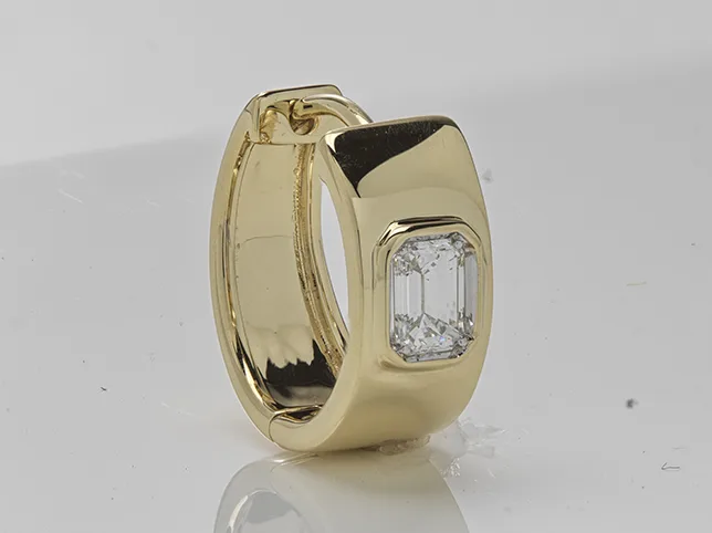 Vintage gold huggie earring with a baguette stone before small-piece retouching